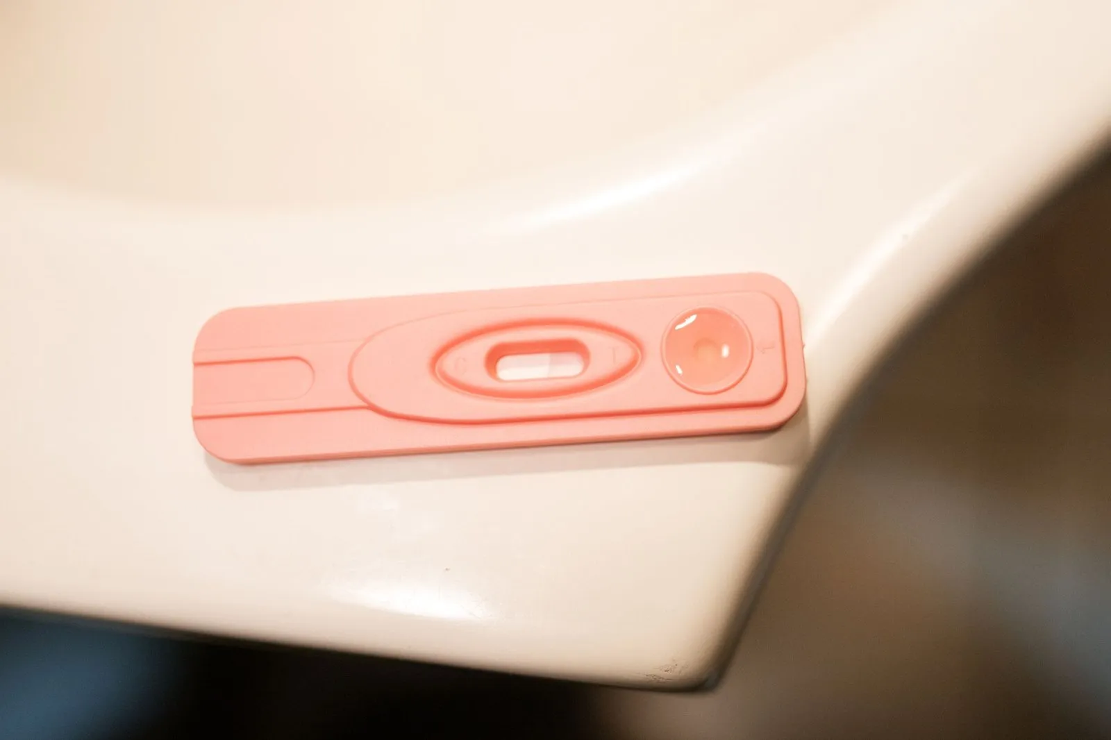 Test de grossesse urinaire posé sur un comptoir, avec boîte de pharmacie et étiquette de prix visible